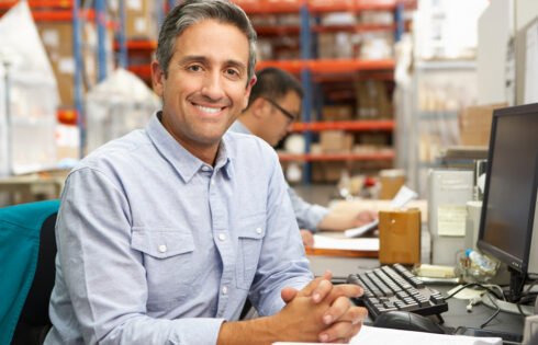 Businessman Working At Desk In Warehouse