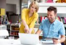 Two bookshop managers working on laptop