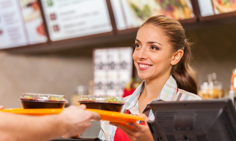 Restaurant worker serving two fast food meals